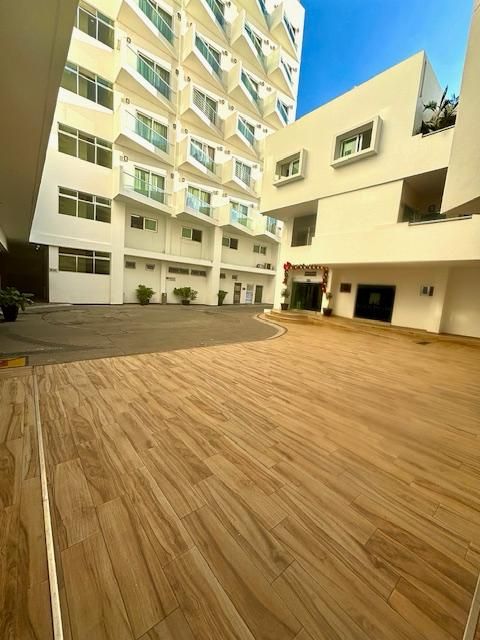 Un gran edificio blanco con un piso de madera en el frente.