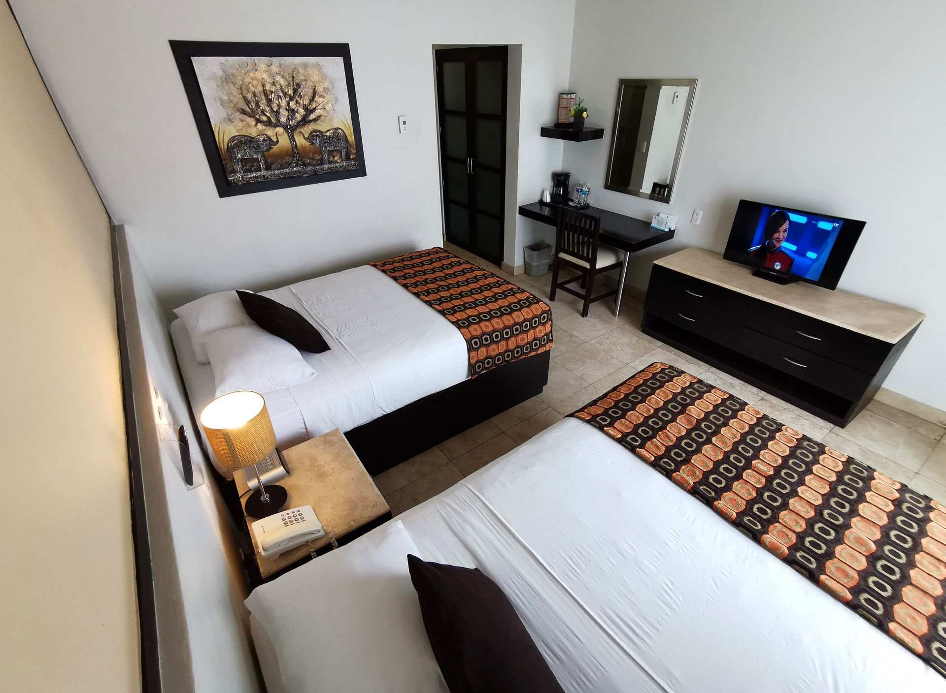 A hotel room with two beds and a television