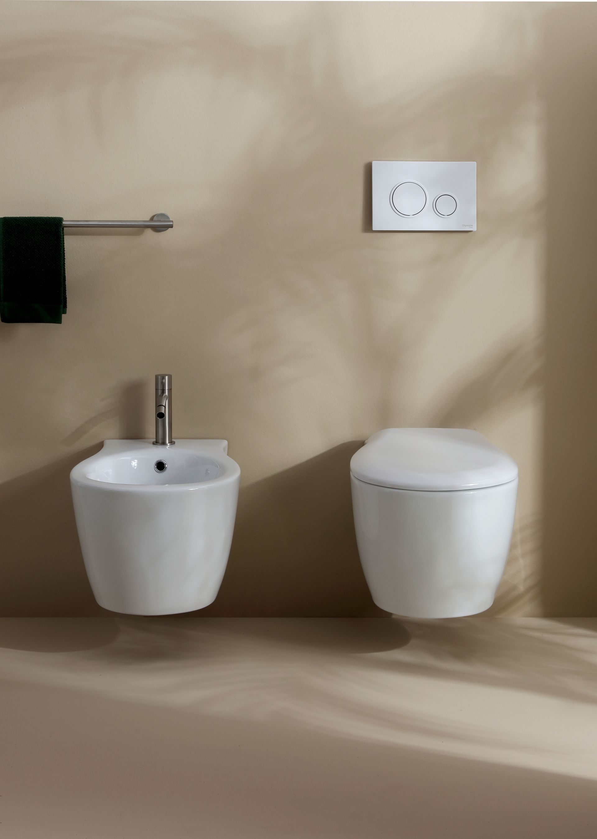 WC e bidet sospesi in un bagno con portasciugamani.