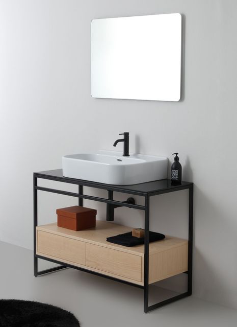 Mobile da bagno moderno con struttura in metallo nero, lavabo a appoggio e mobiletto in legno. Sopra è appeso uno specchio.