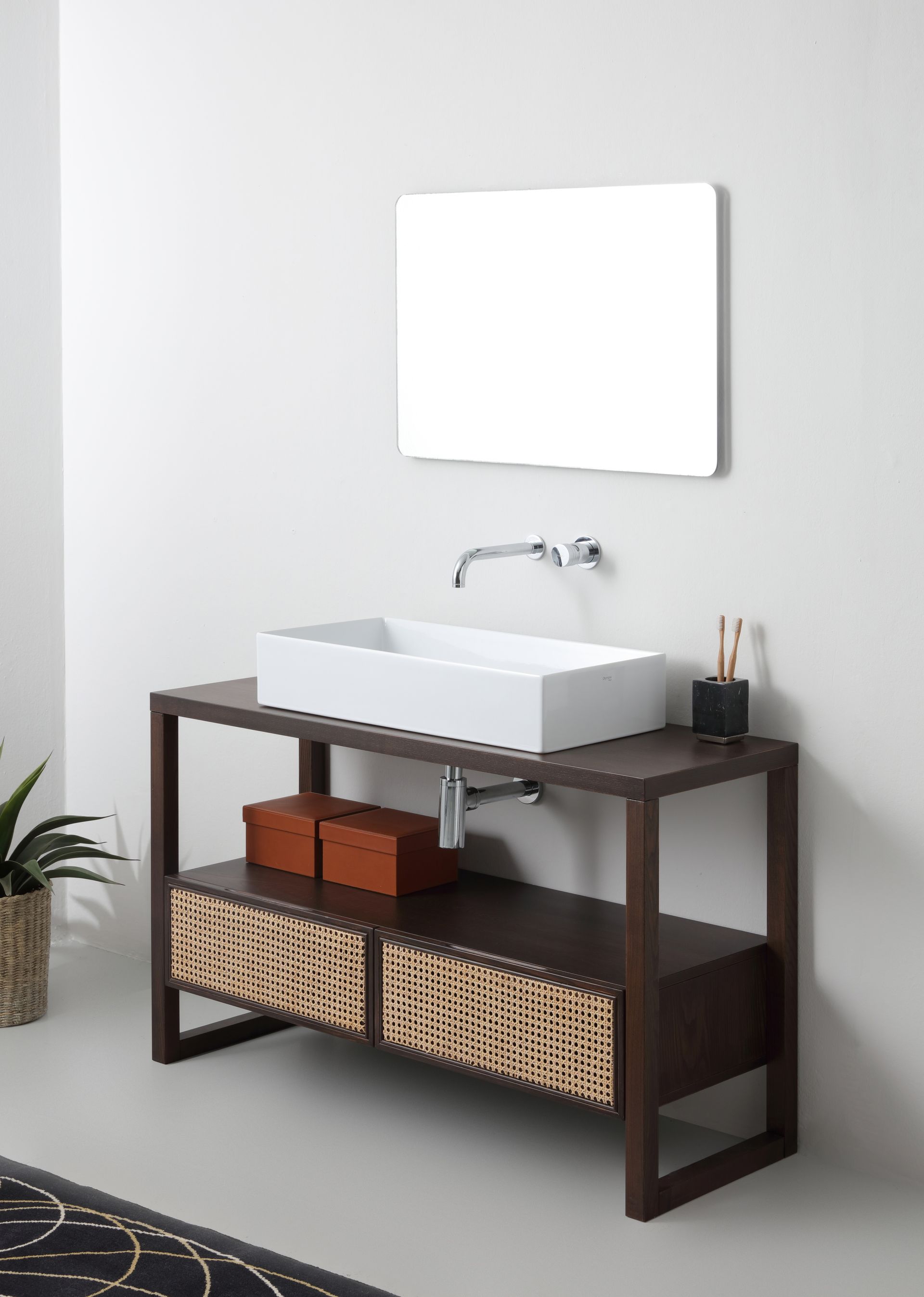 Mobile da bagno in legno con lavandino rettangolare bianco, cestini intrecciati e specchio.