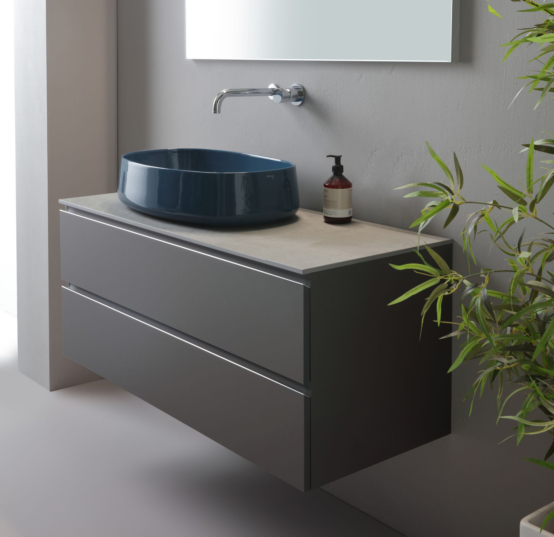 Mobile lavabo sospeso grigio con lavabo blu, piano d'appoggio neutro e grande specchio.