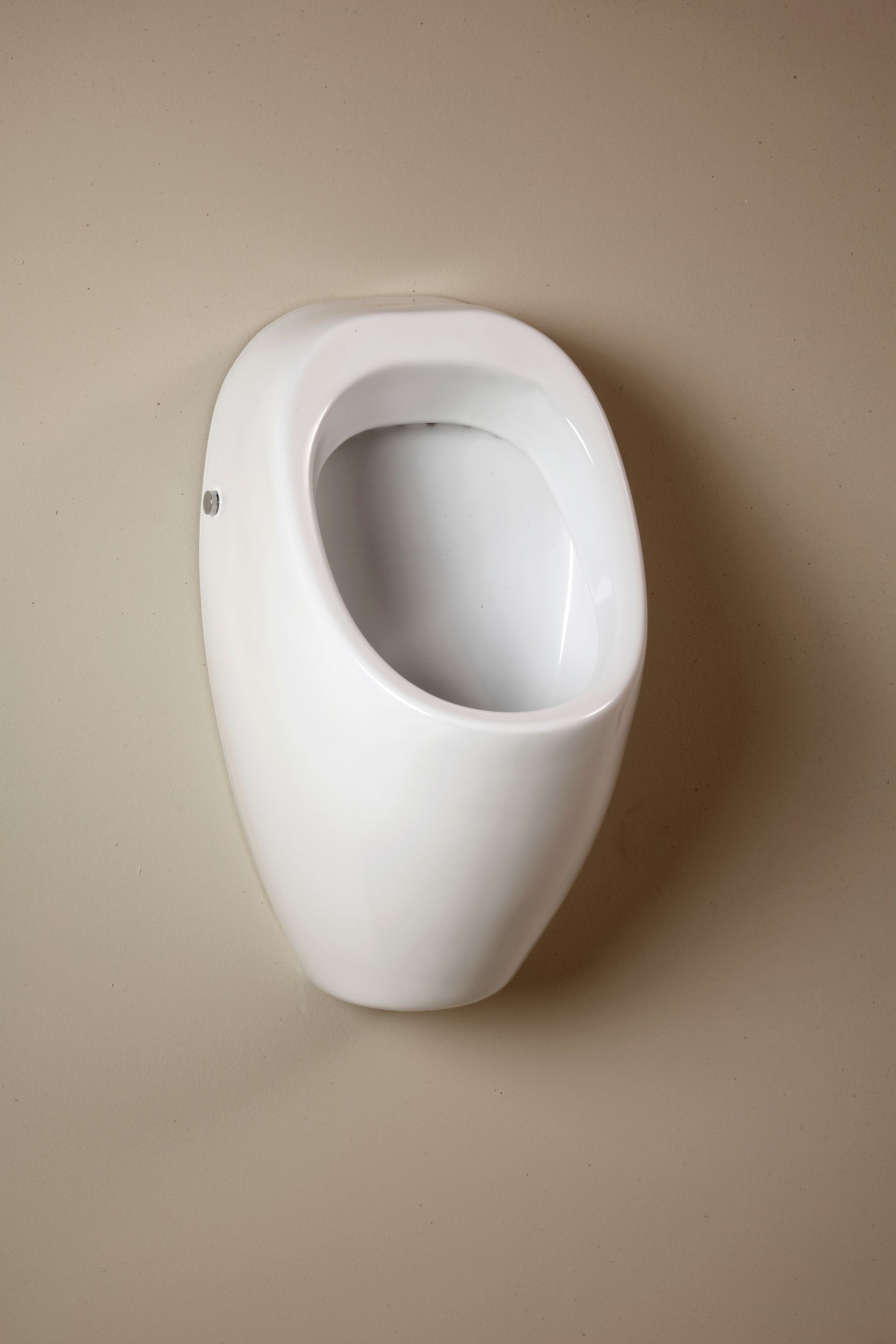 Orinatoio bianco montato su una parete beige.