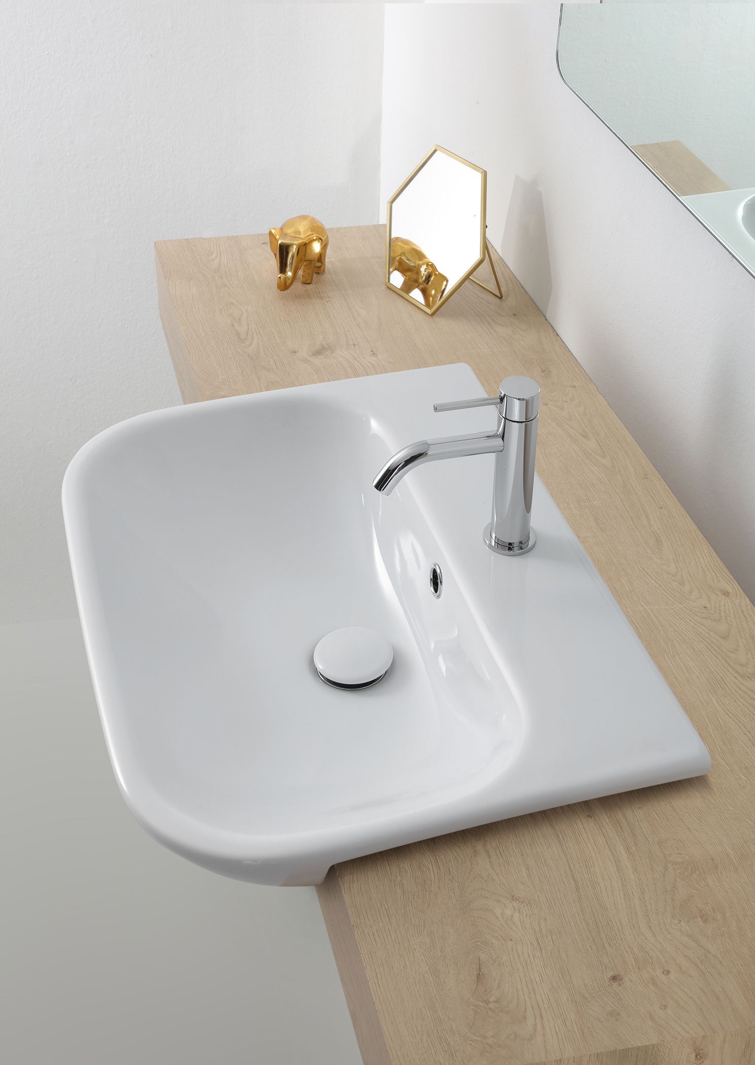 Lavandino bianco con rubinetto cromato, su un piano di lavoro beige, con dettagli dorati.