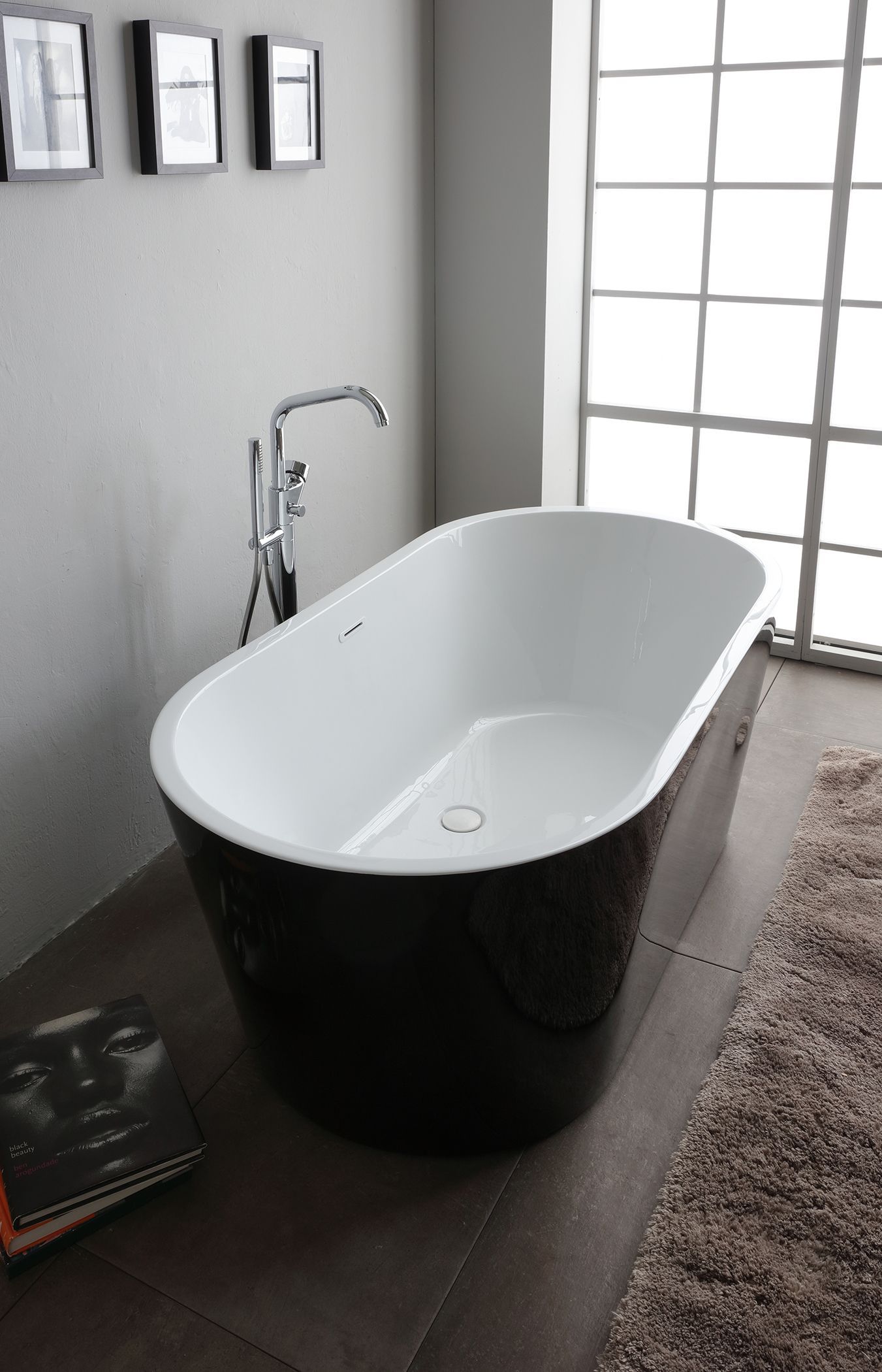 Vasca da bagno indipendente bianca e nera in un bagno moderno.