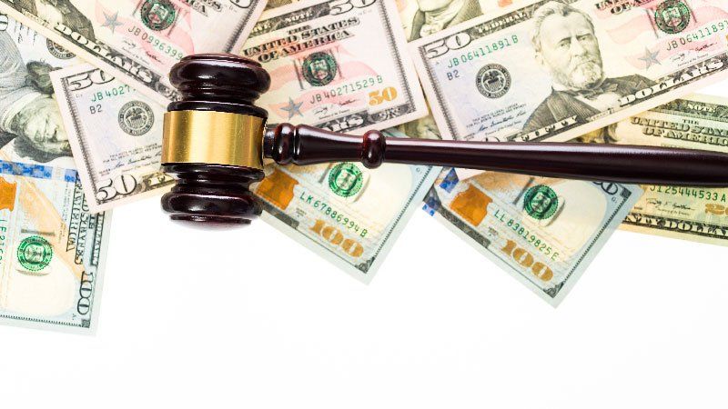 Gavel resting on 50 and 100 dollar bills