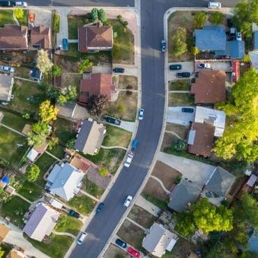 An aerial view of a residential neighborhood with lots of houses and trees.