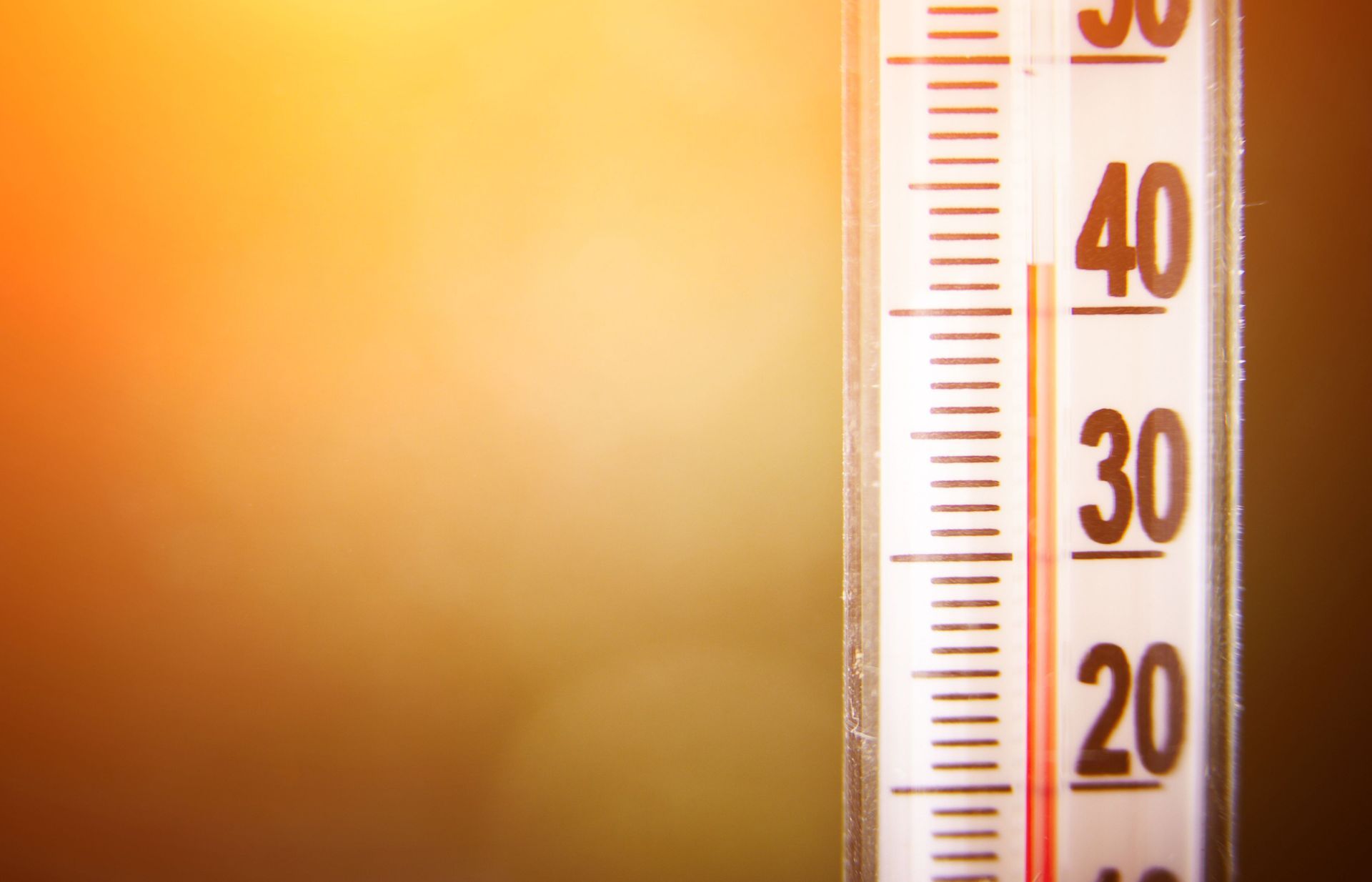 Thermometer showing temperature around 40 degrees, with a bright yellow background.