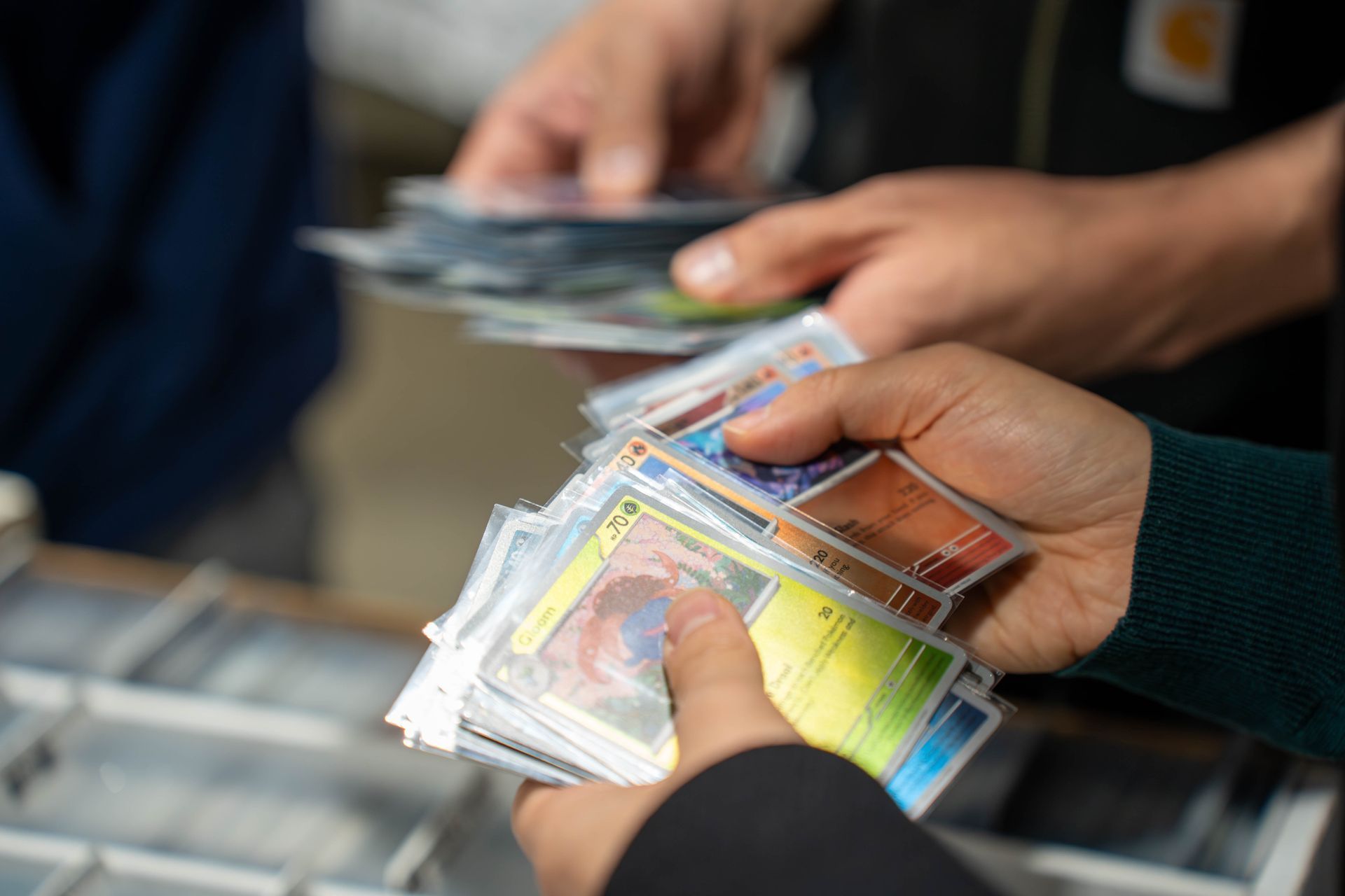hands holding pokemon cards