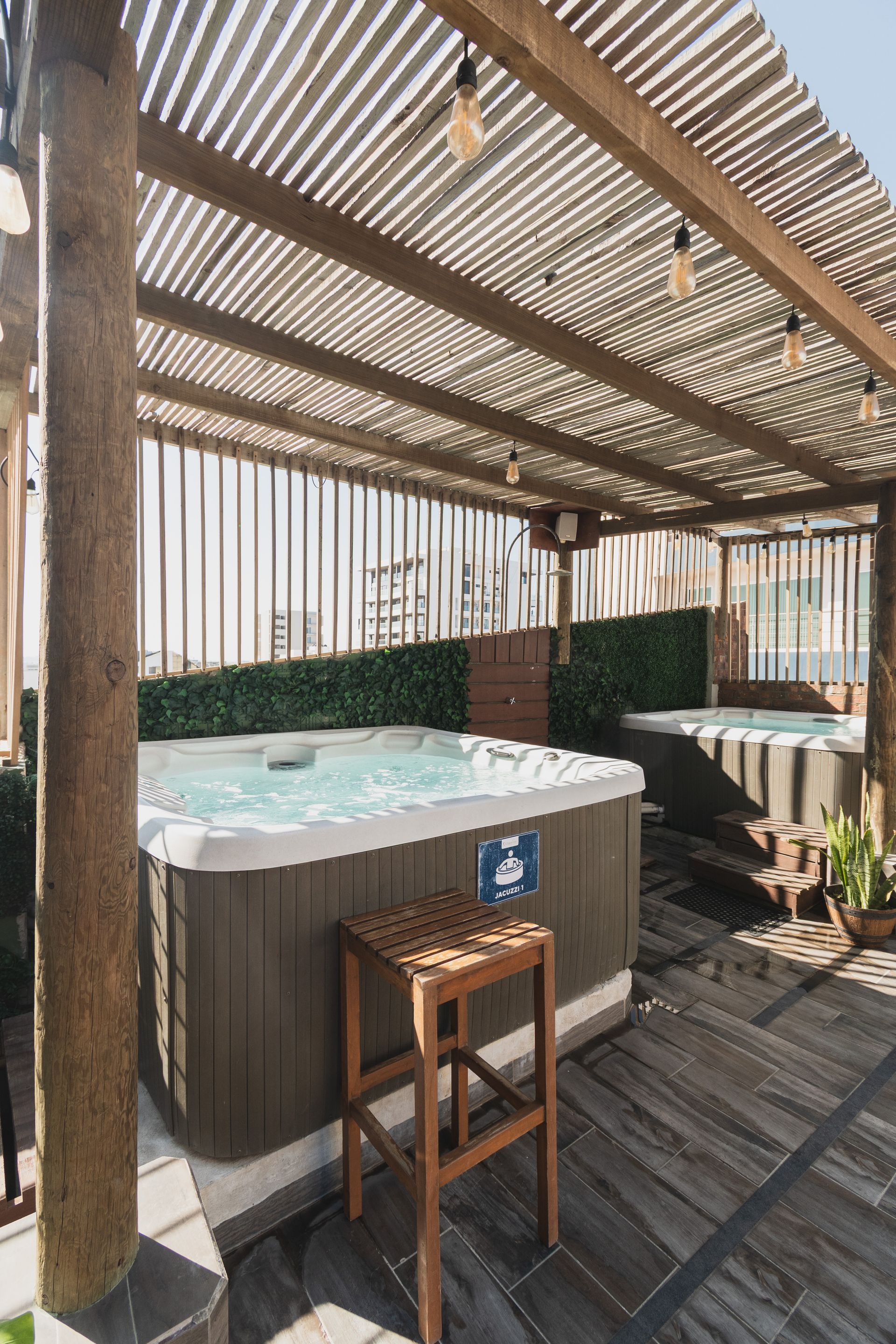 Hay dos sillones de madera en un patio al lado de un jacuzzi.