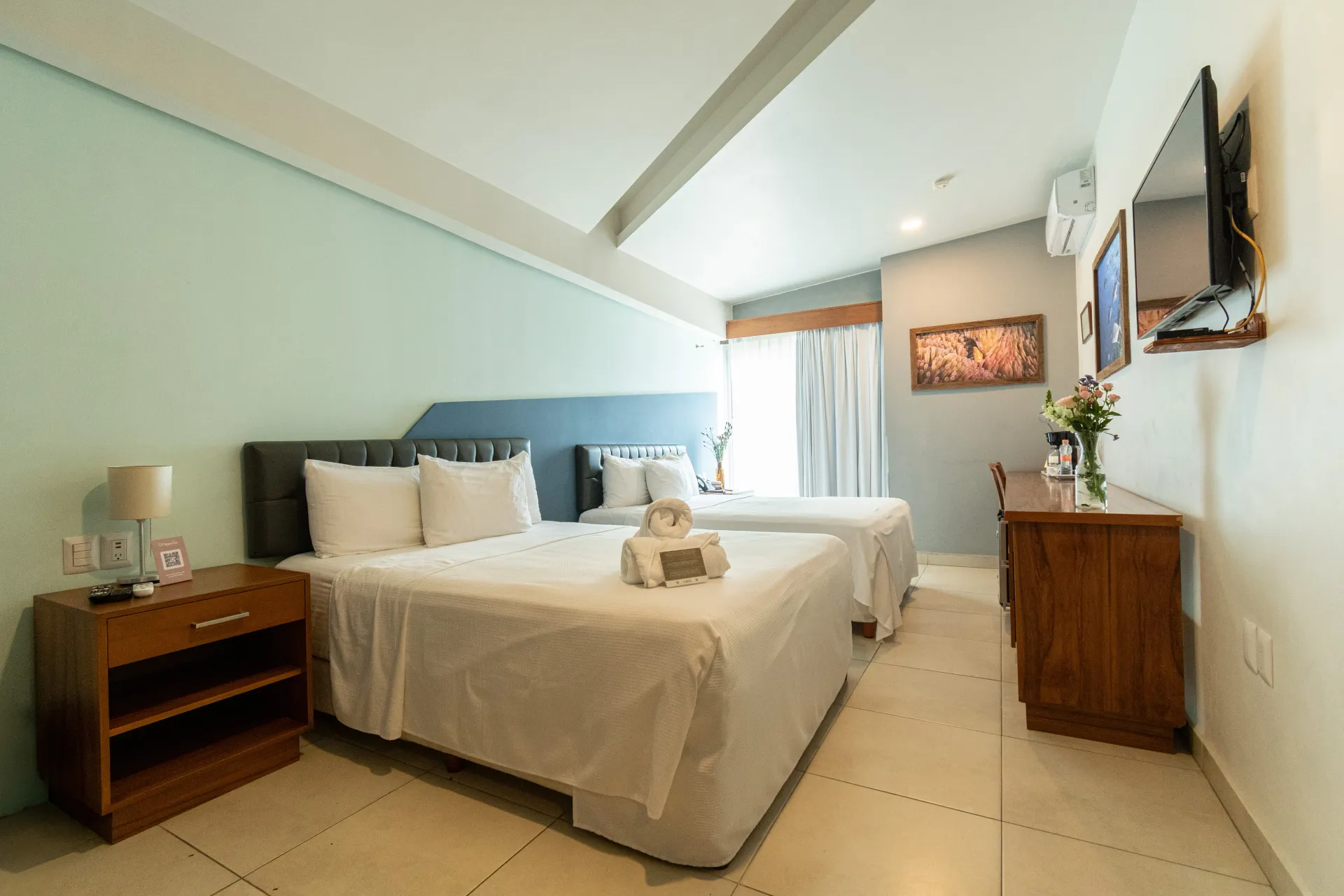 Una habitación de hotel con dos camas y una mesita de noche.