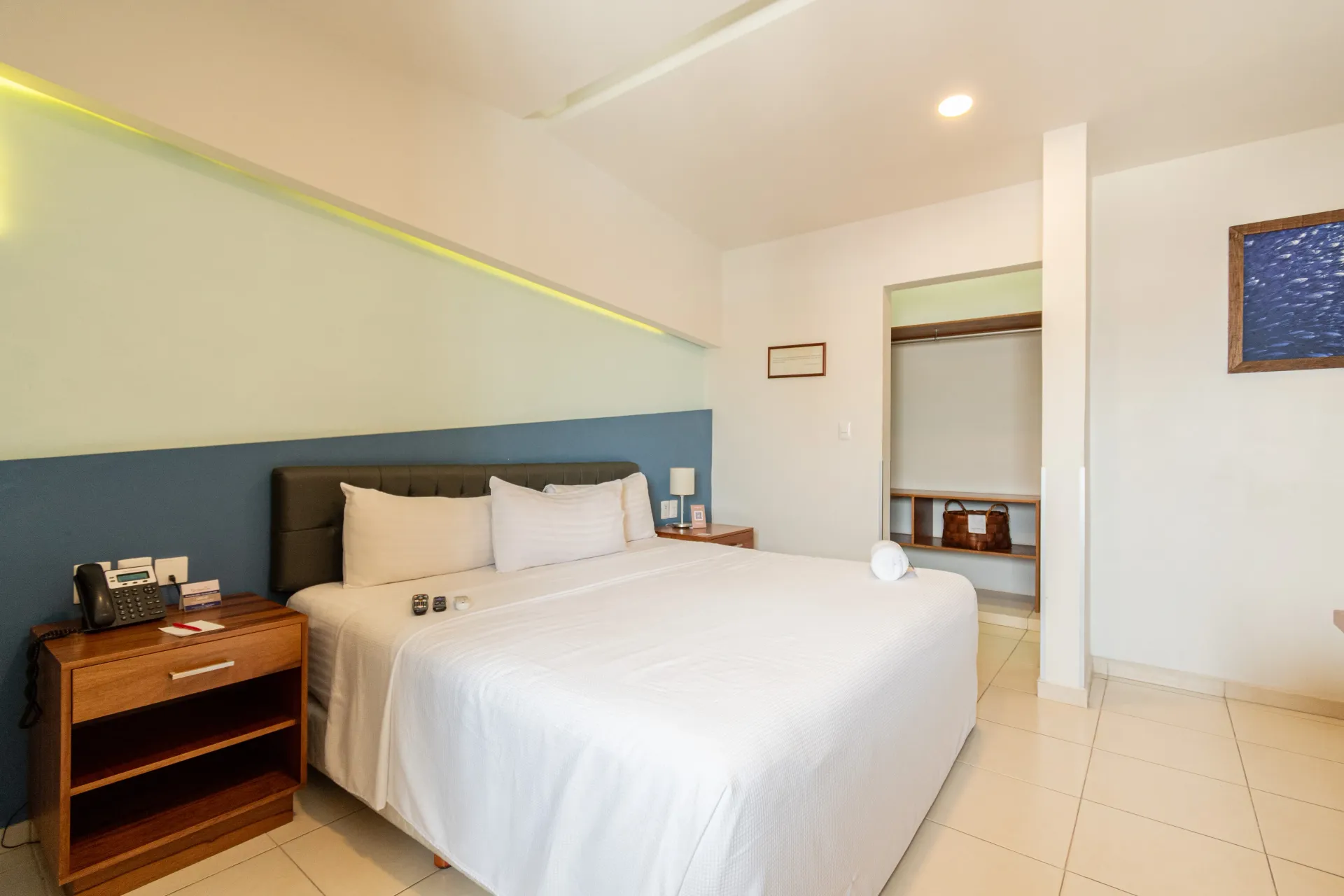A hotel room with a bed and a surfboard on the wall