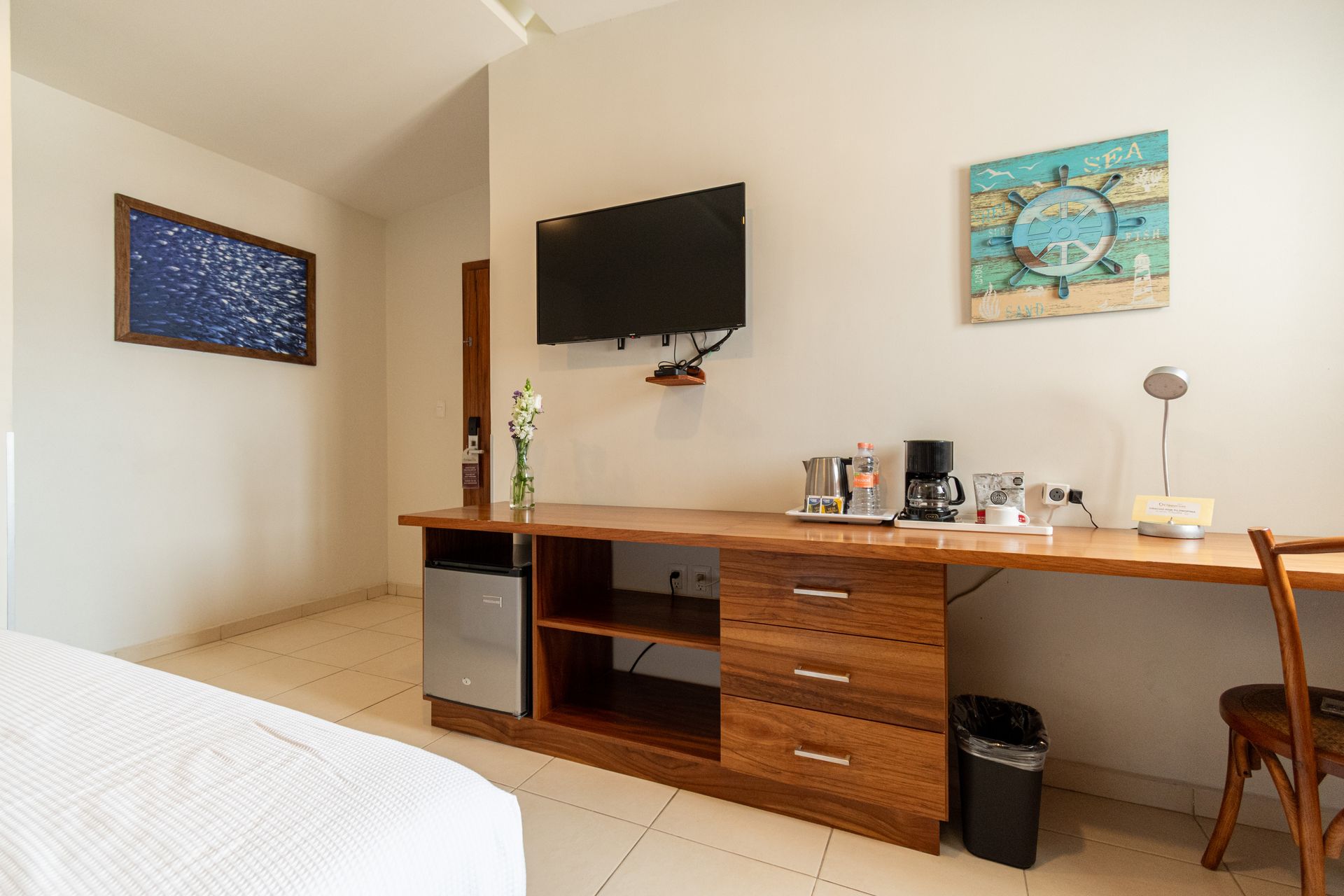 A hotel room with a bed and a green light on the wall.