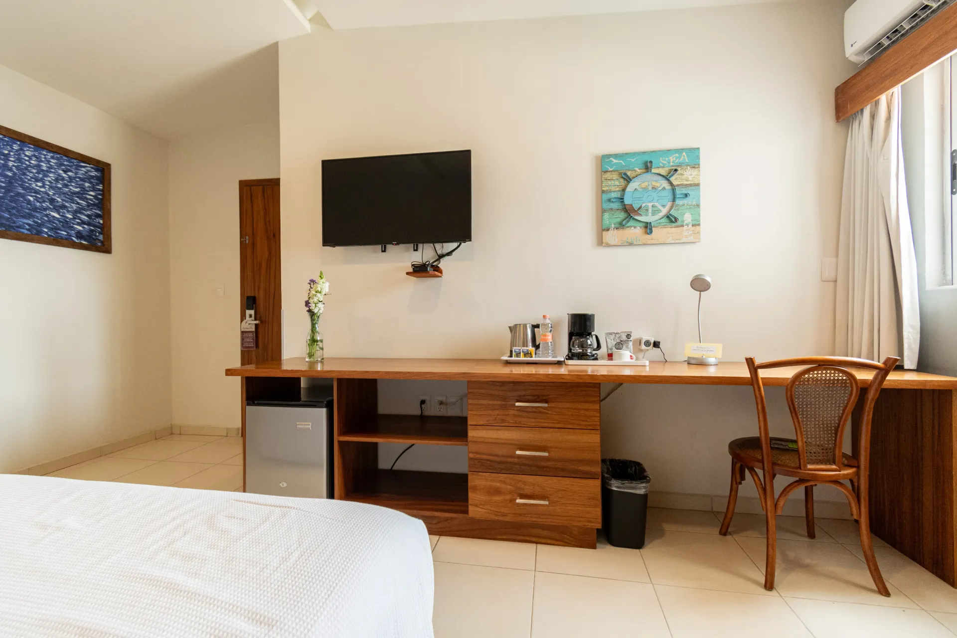 A hotel room with a bed and a surfboard on the wall