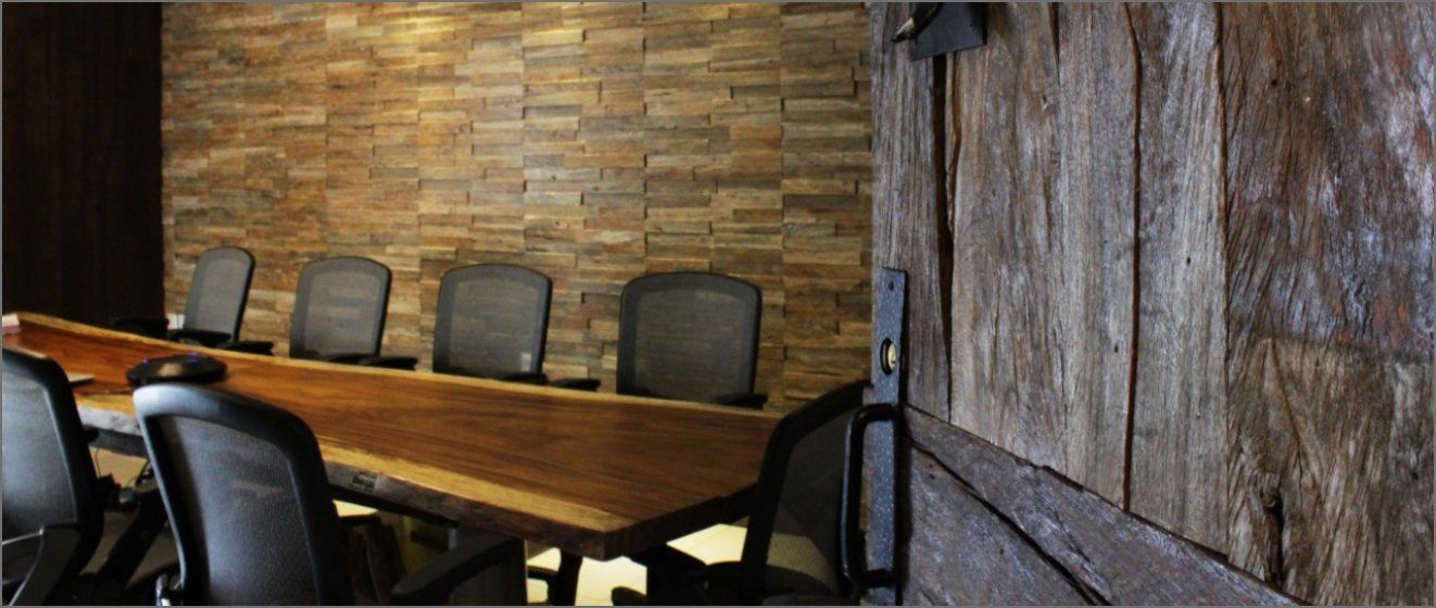 Una sala de conferencias con una mesa larga de madera y sillas.