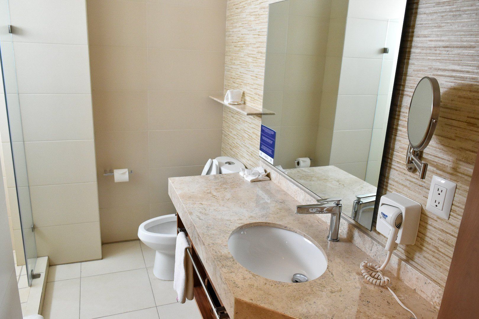 Un baño con lavabo, inodoro y espejo.