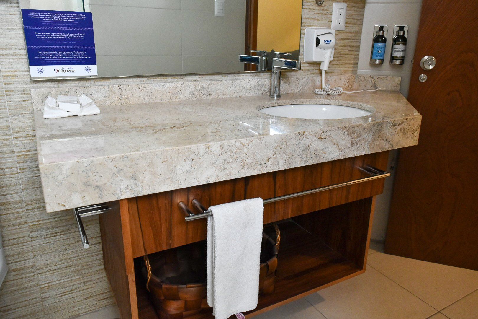 Un baño con lavabo, espejo y toallero.