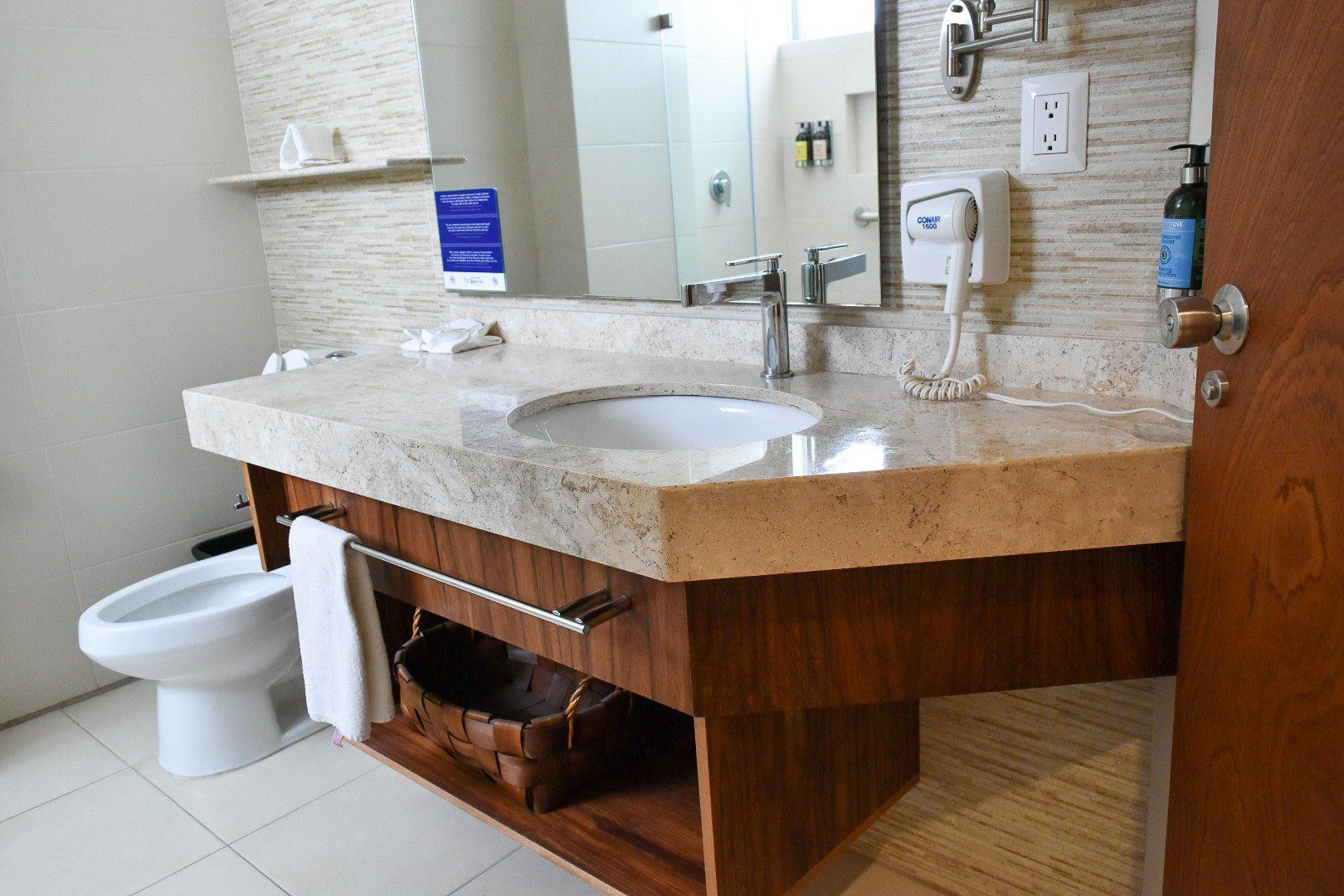 Un baño con lavabo, inodoro y espejo.