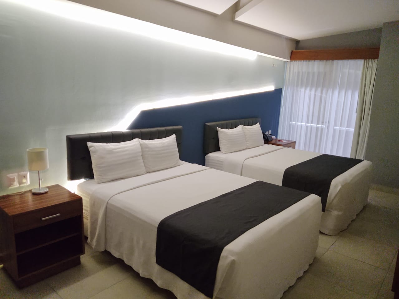 A hotel room with two beds and a nightstand