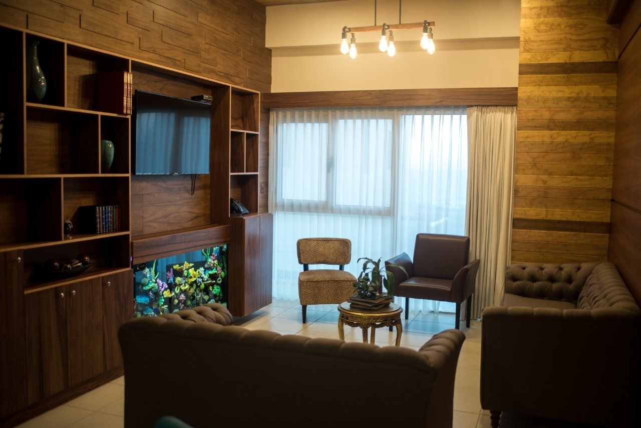 Una sala de estar con un sofá, sillas y un televisor.