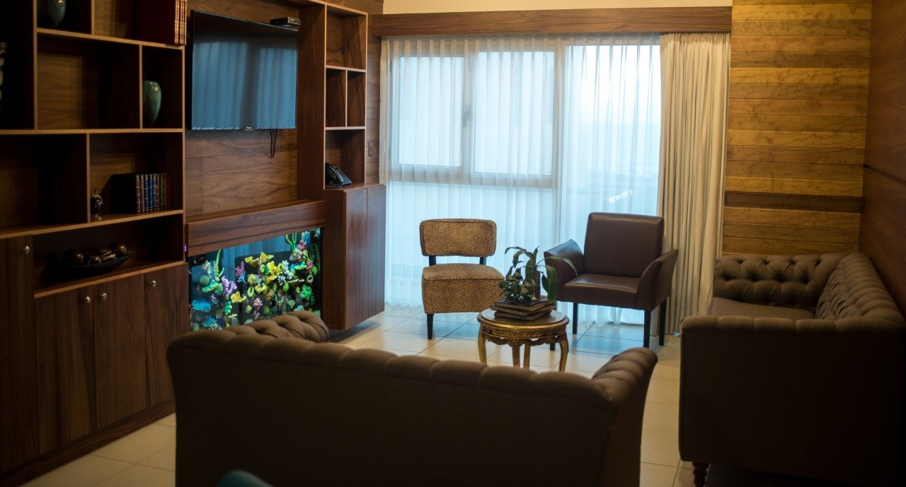 A living room with a couch , chairs , and a television.