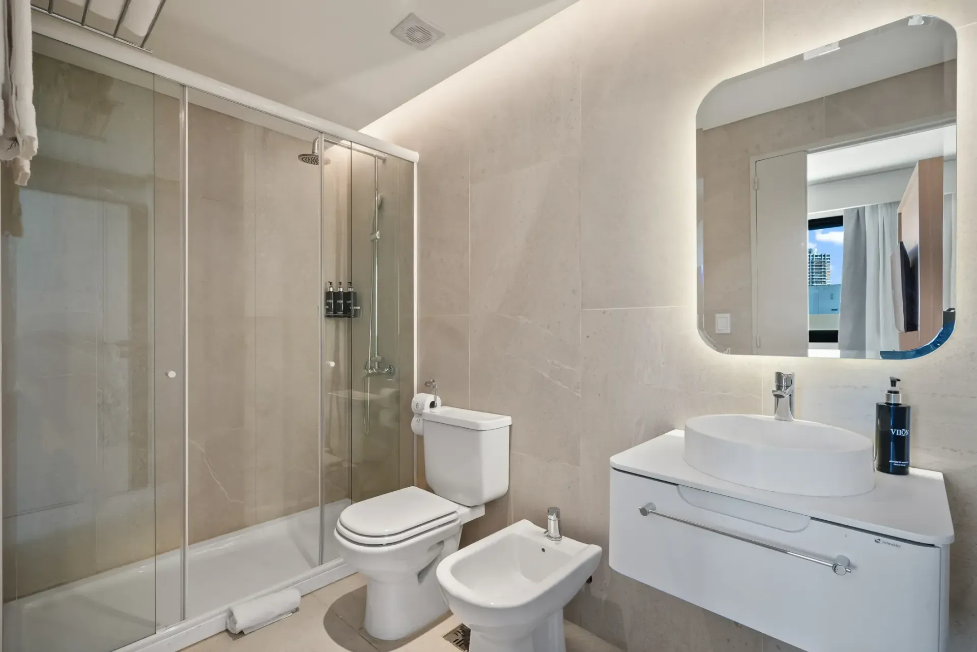 Un baño con inodoro, bidet, lavabo y ducha.