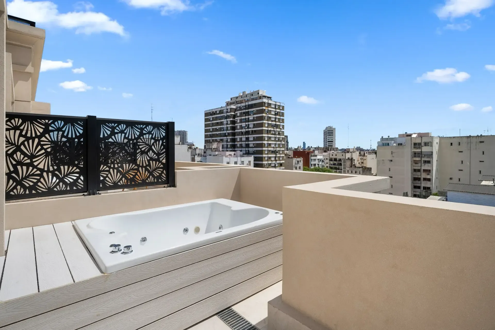 Una bañera de hidromasaje en un balcón con vistas a la ciudad.