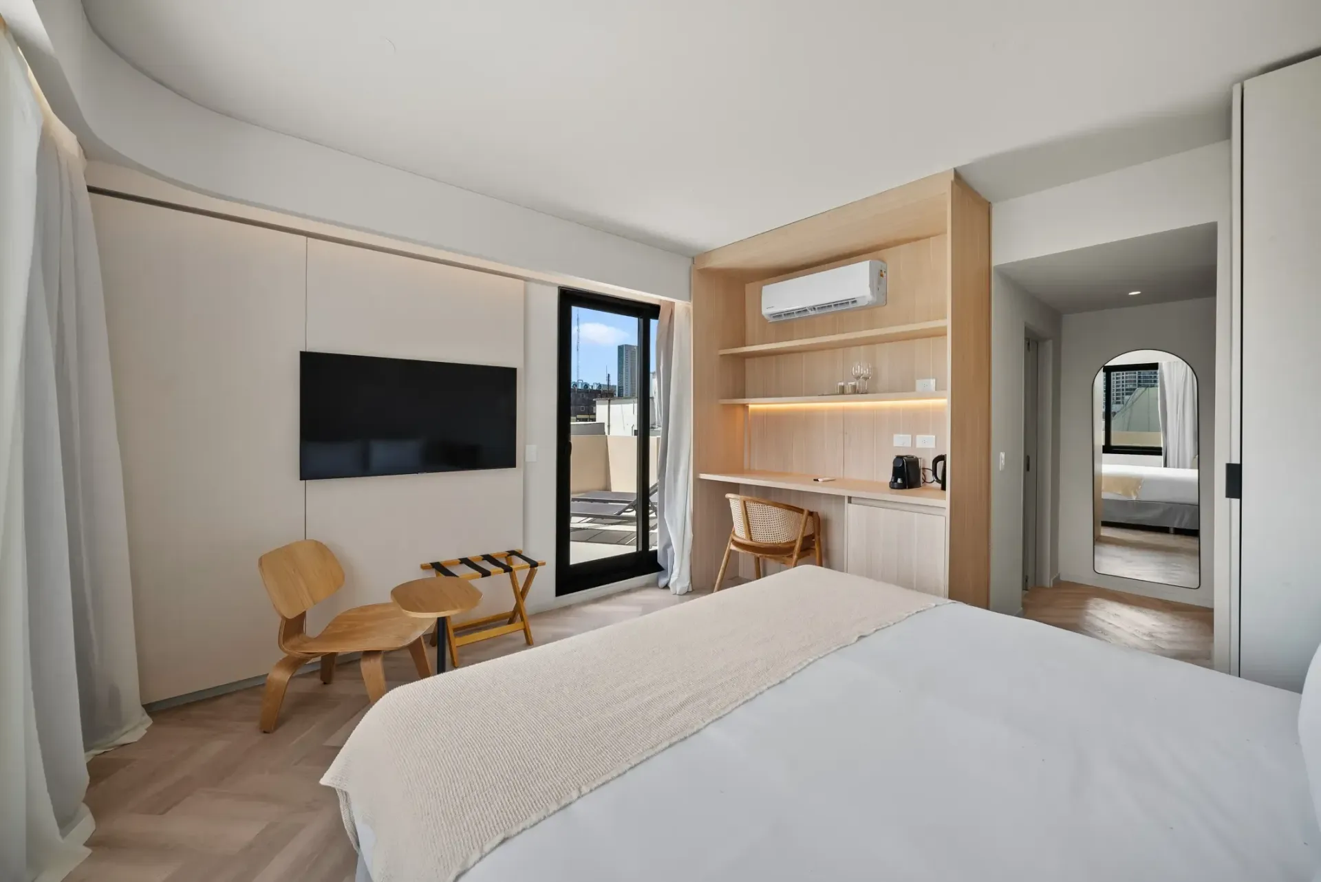 Una habitación de hotel con una cama, una silla, un escritorio y una televisión.