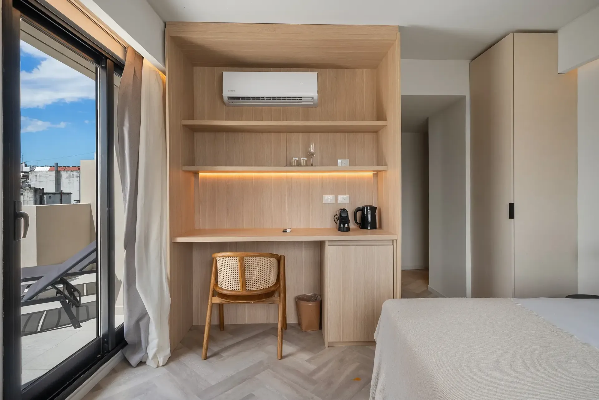 Un dormitorio con cama, escritorio, silla y ventana.
