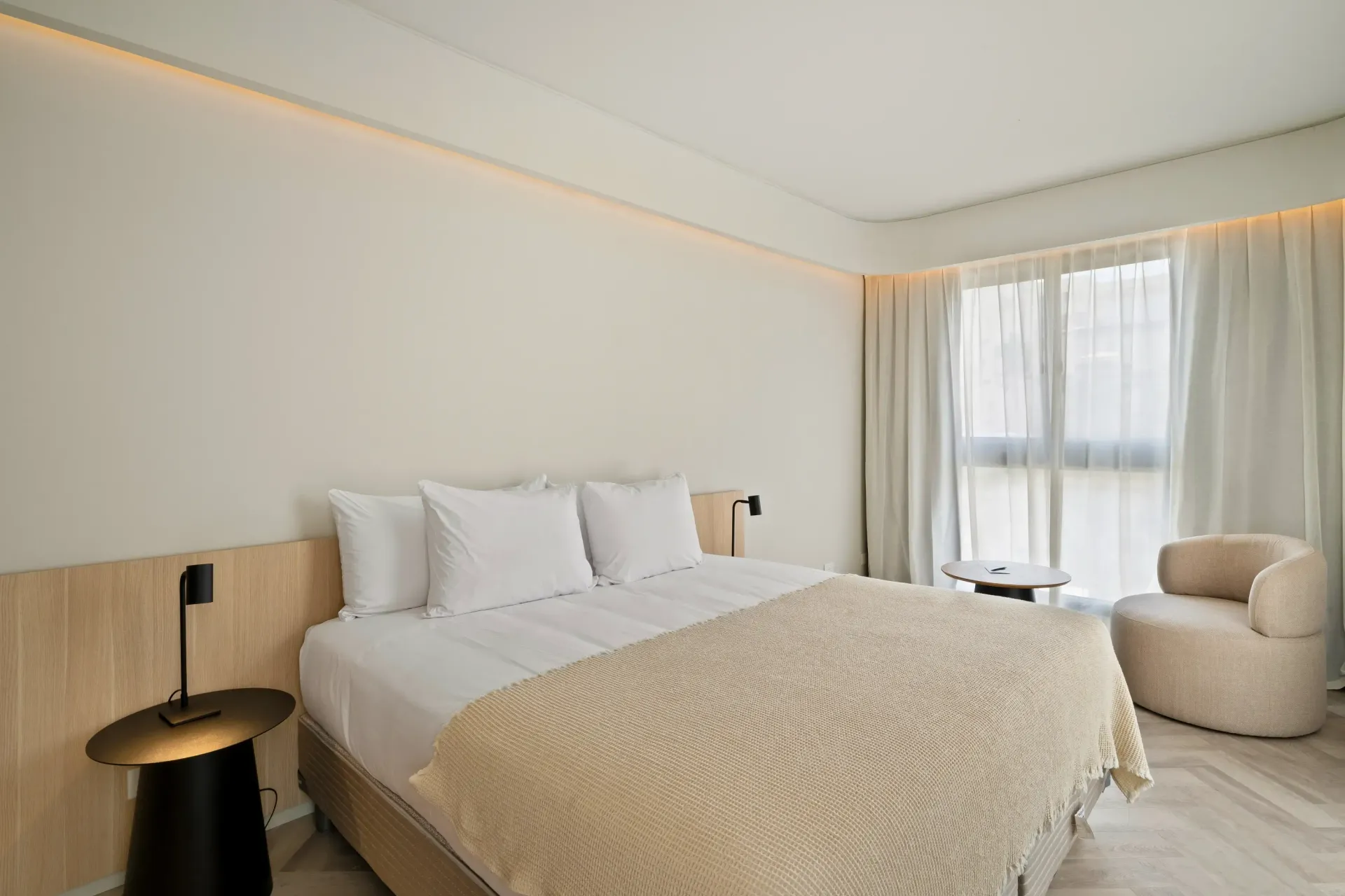 Una habitación de hotel con una cama grande y una silla.