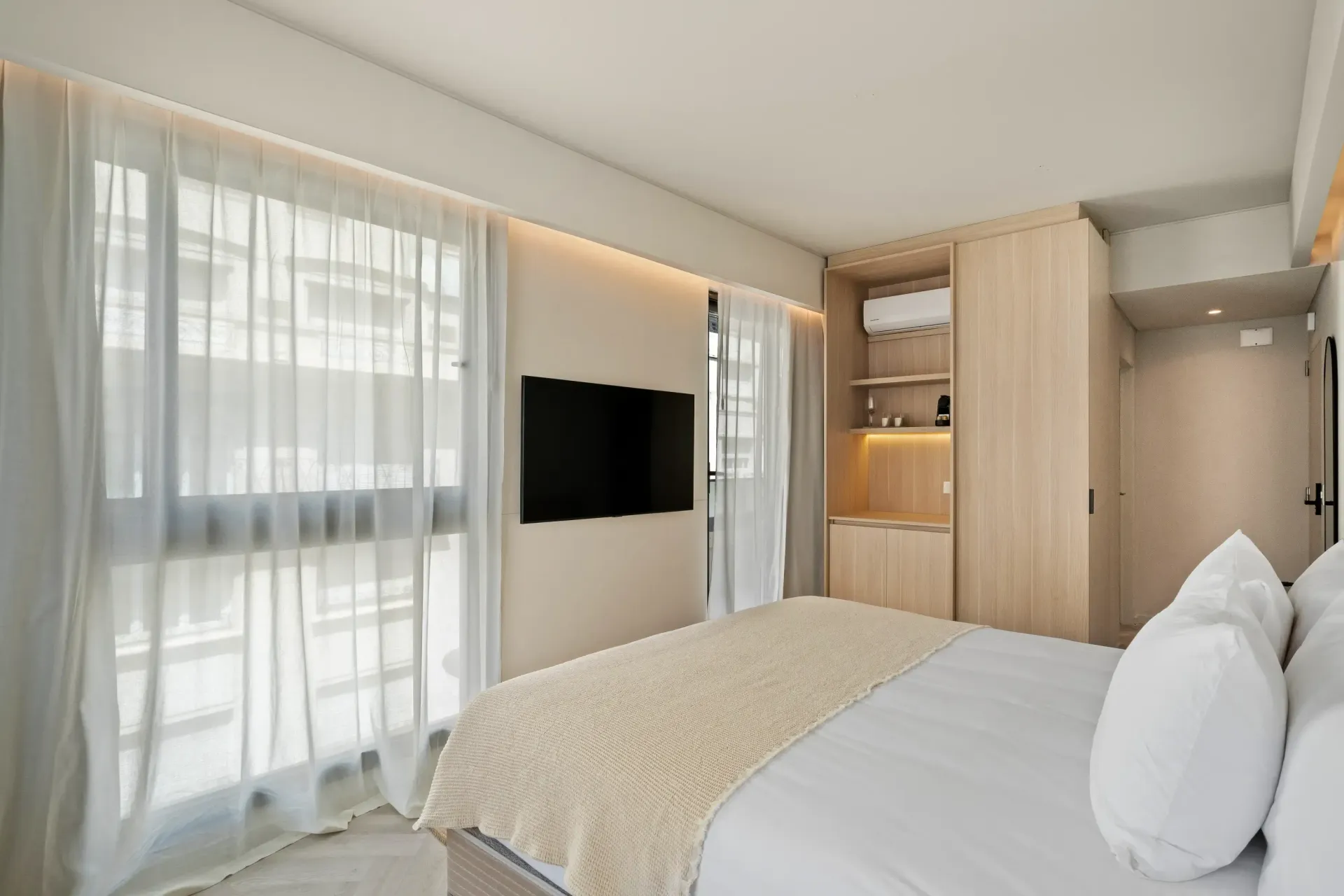Una habitación de hotel con una cama tamaño king y un televisor de pantalla plana.