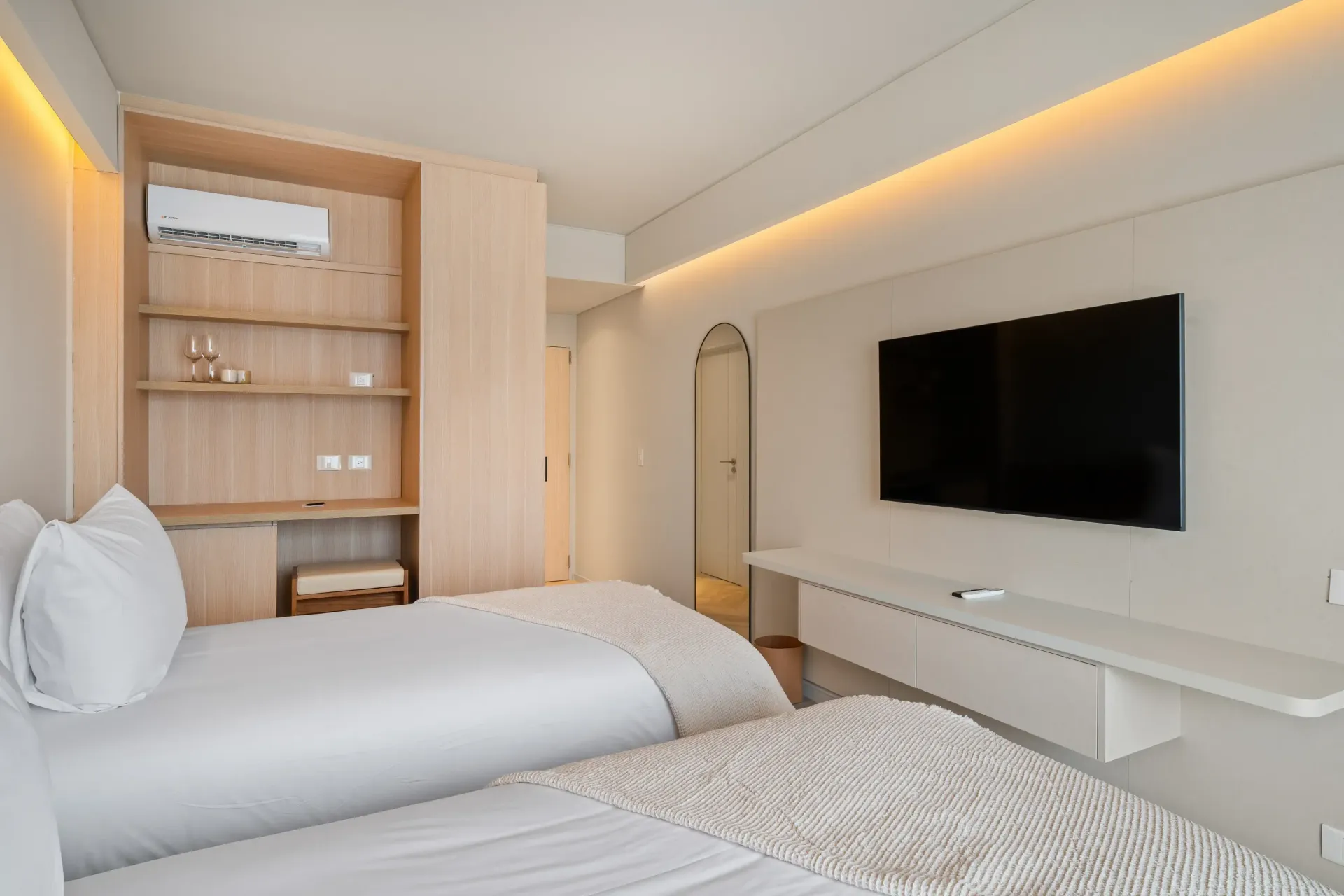 Una habitación de hotel con dos camas y un televisor de pantalla plana.