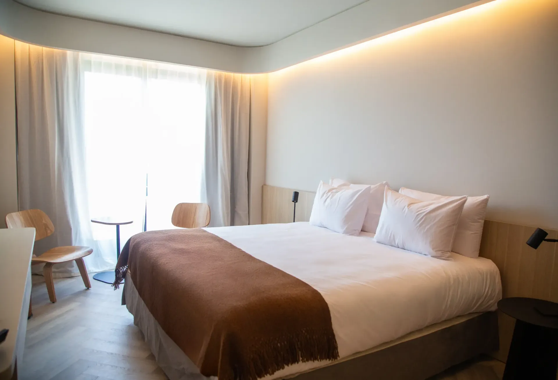 Una habitación de hotel con una cama tamaño king y una silla.