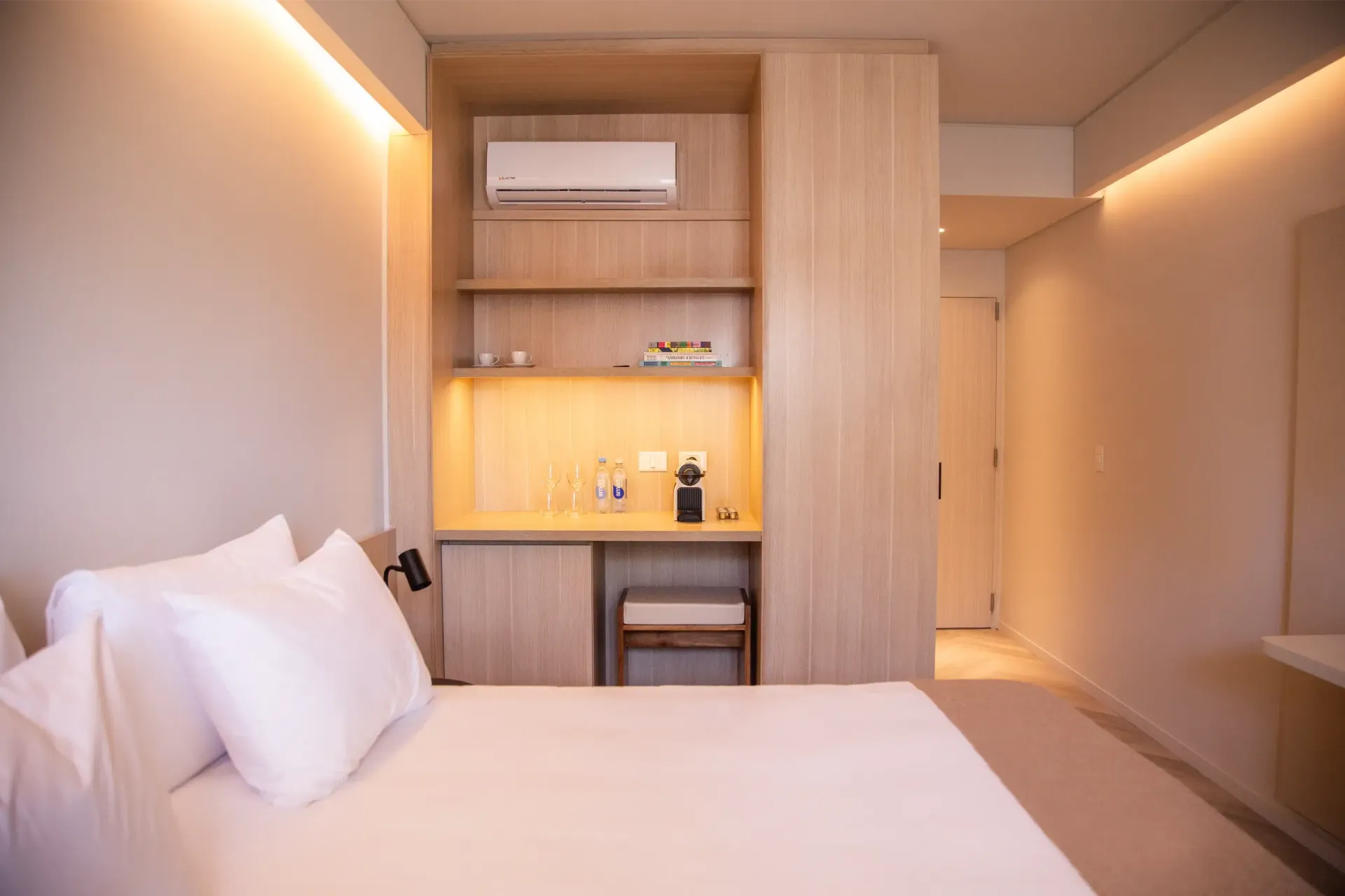 Una habitación de hotel con cama, escritorio y aire acondicionado.