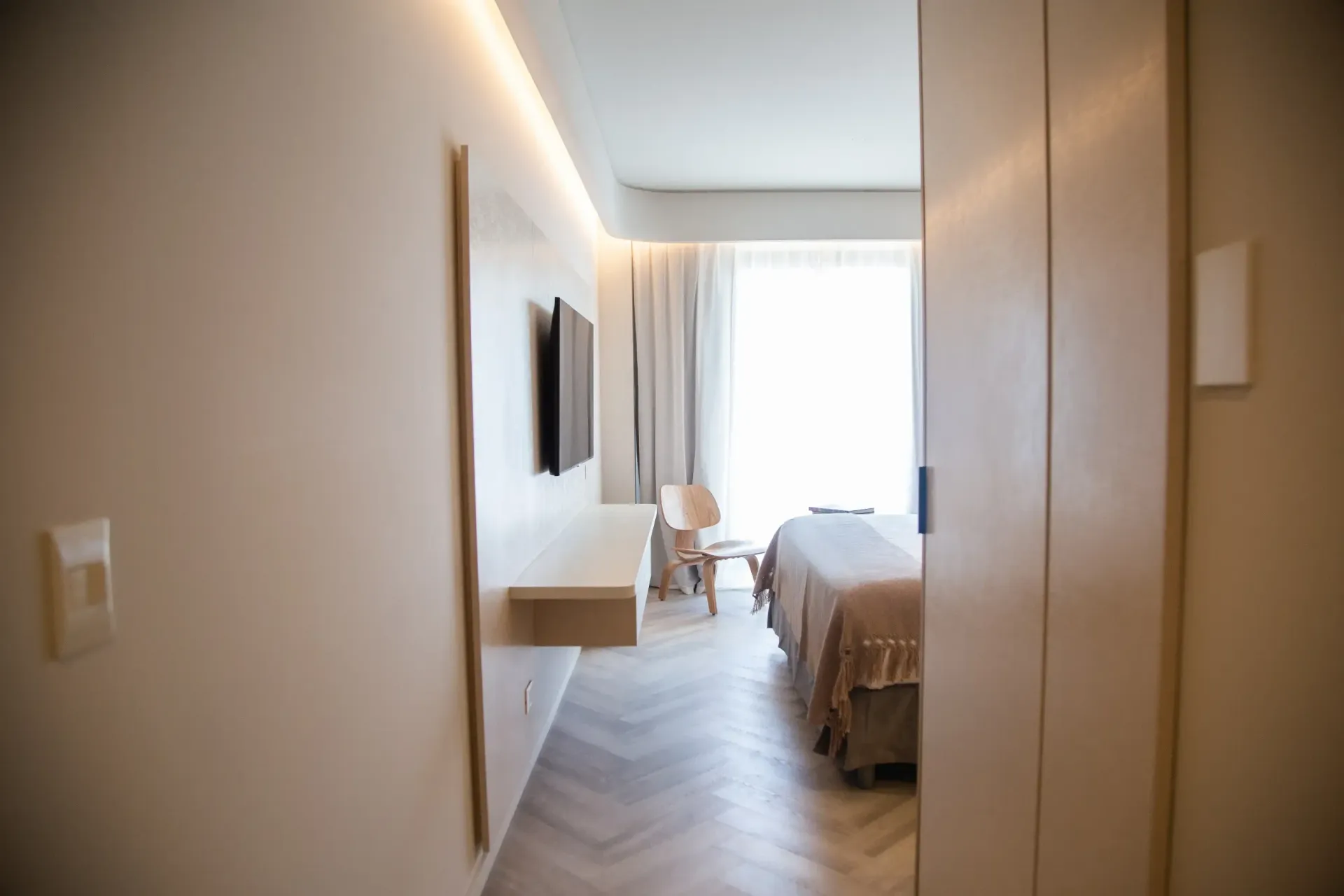Una habitación de hotel con una cama, una silla y una televisión.