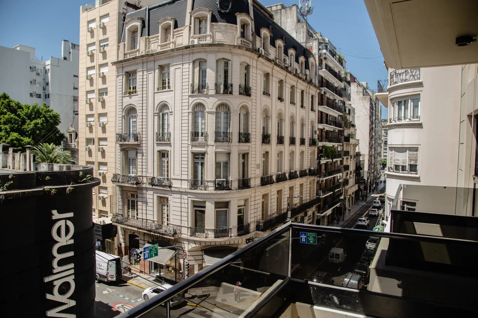 Un balcón con vistas a una calle de la ciudad con un gran edificio al fondo.