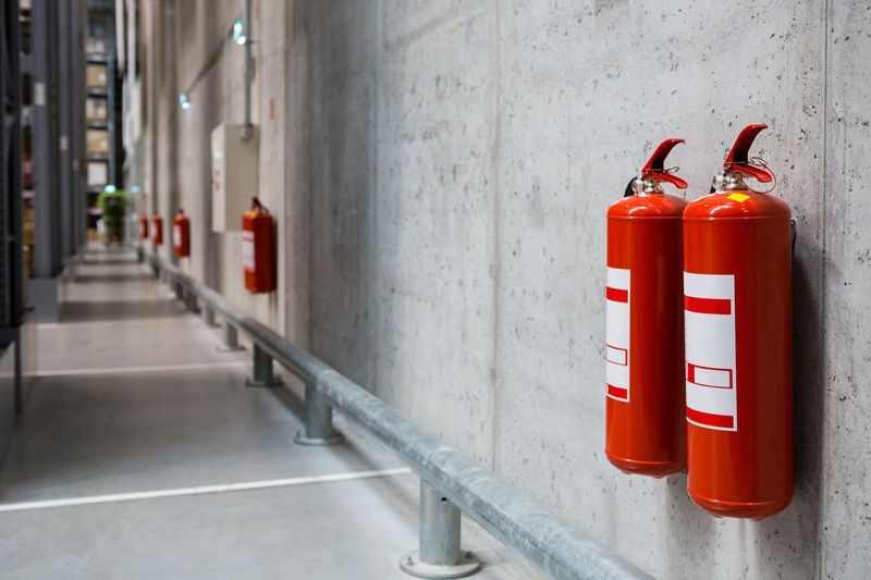 Two Red Fire Extinguishers Hang on Concrete Wall - Upper Hunter Valley NSW