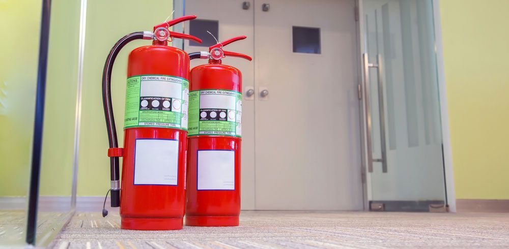 Two Red Fire Extinguishers by Glass Door - Central Coast NSW