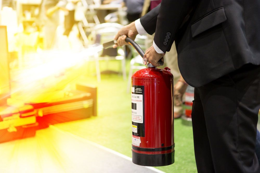 A Suited Man Holds a Red Fire Extinguisher - Hunter Valley NSW