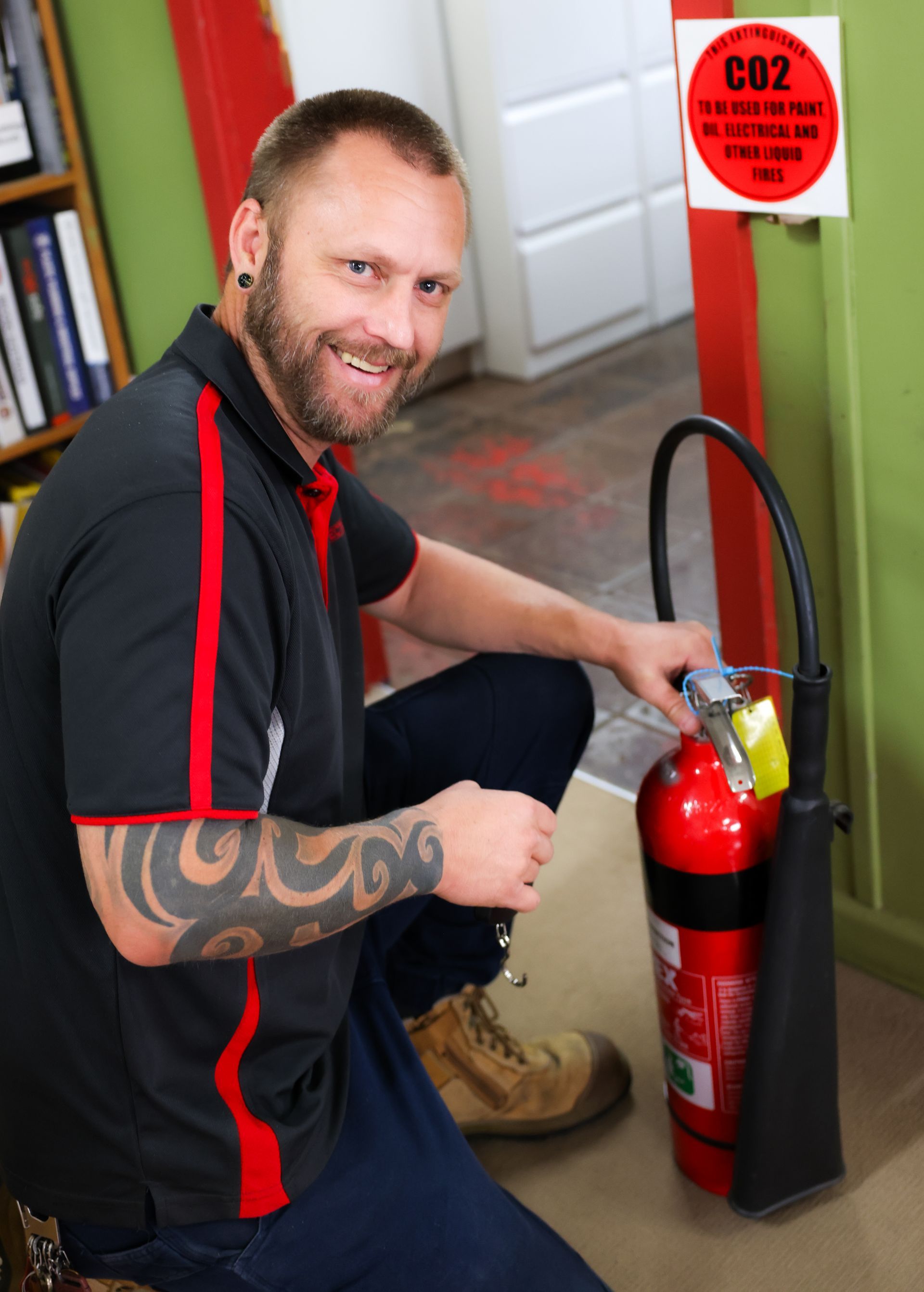 Person Taking Notes Next to Red Fire Extinguisher Cylinders - Muswellbrook NSW
