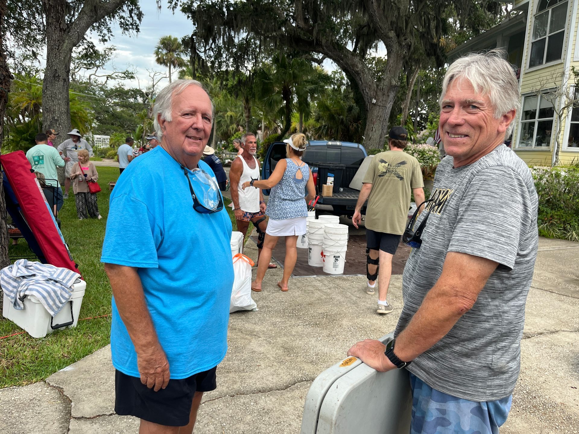 Two men are standing next to each other in front of a group of people.