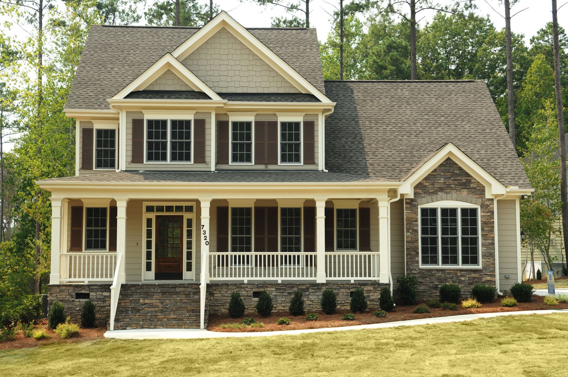 A large house with a large porch and lots of windows