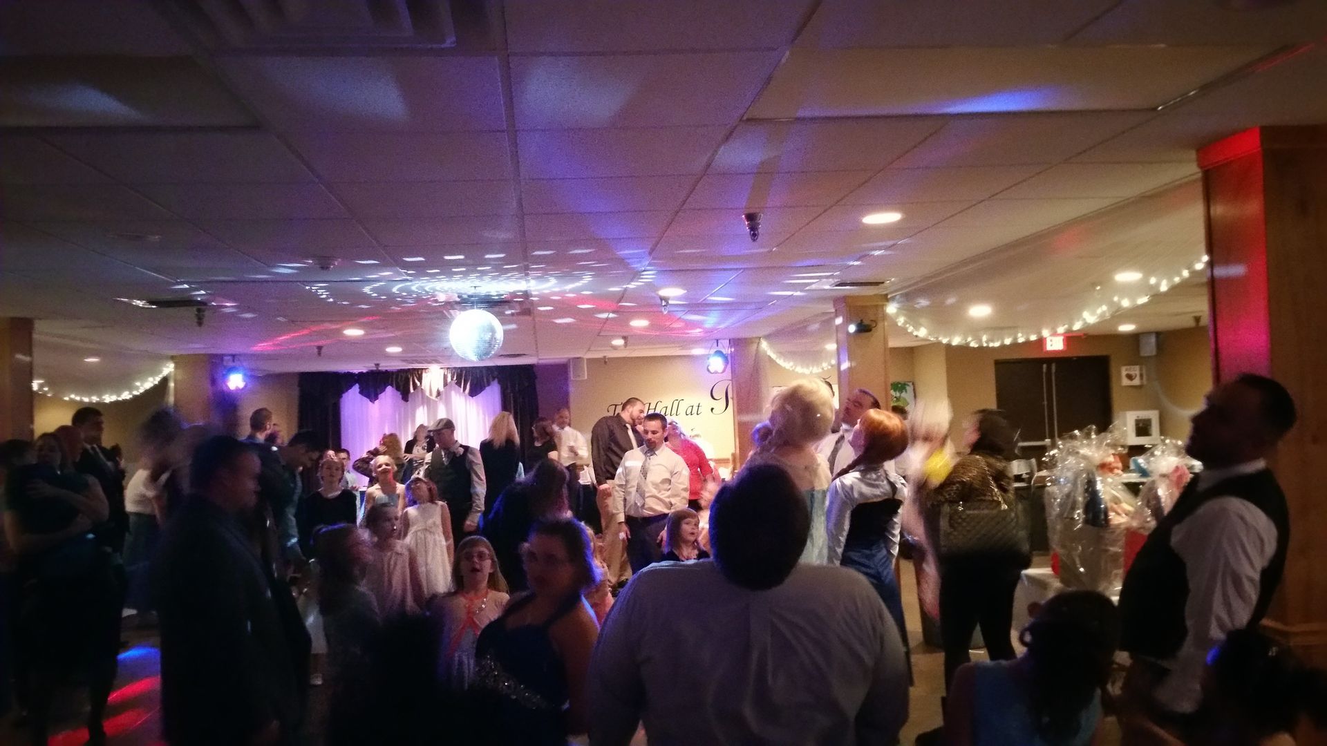 Crowd watching a live band perform in a decorated indoor venue with colorful stage lights