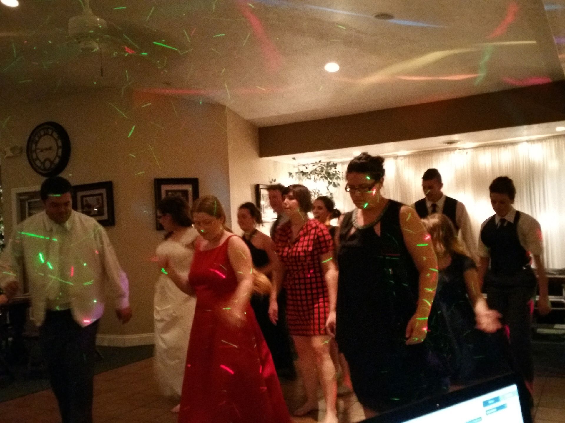 People dancing at a party with colorful light reflections in a decorated room