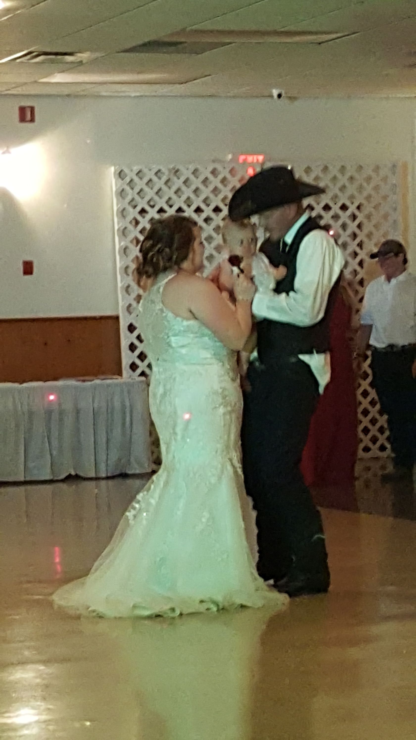 Bride and groom slow dance at a wedding reception in a decorated hall