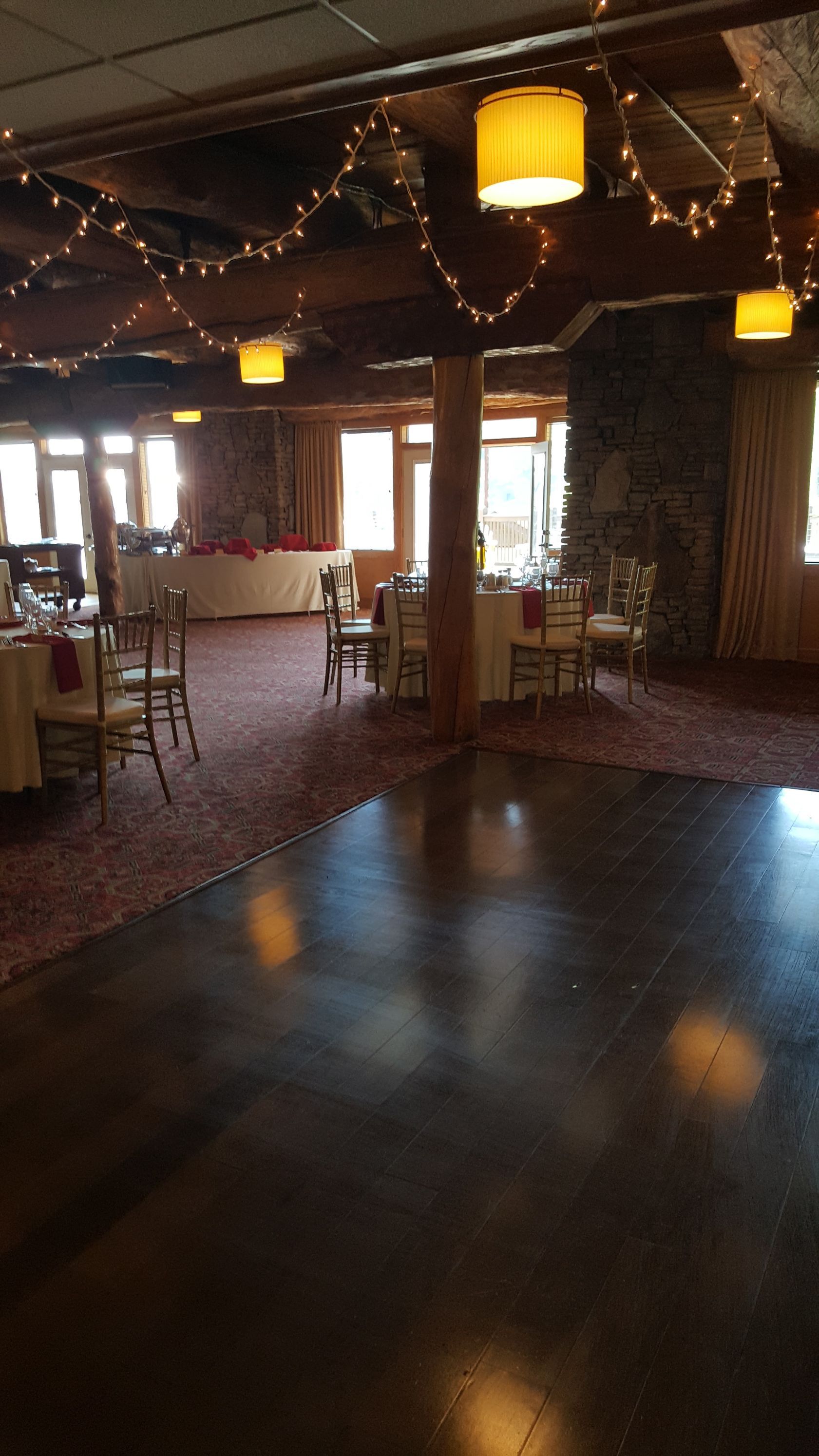 Dim restaurant interior with wooden tables, string lights, and warm hanging lanterns.