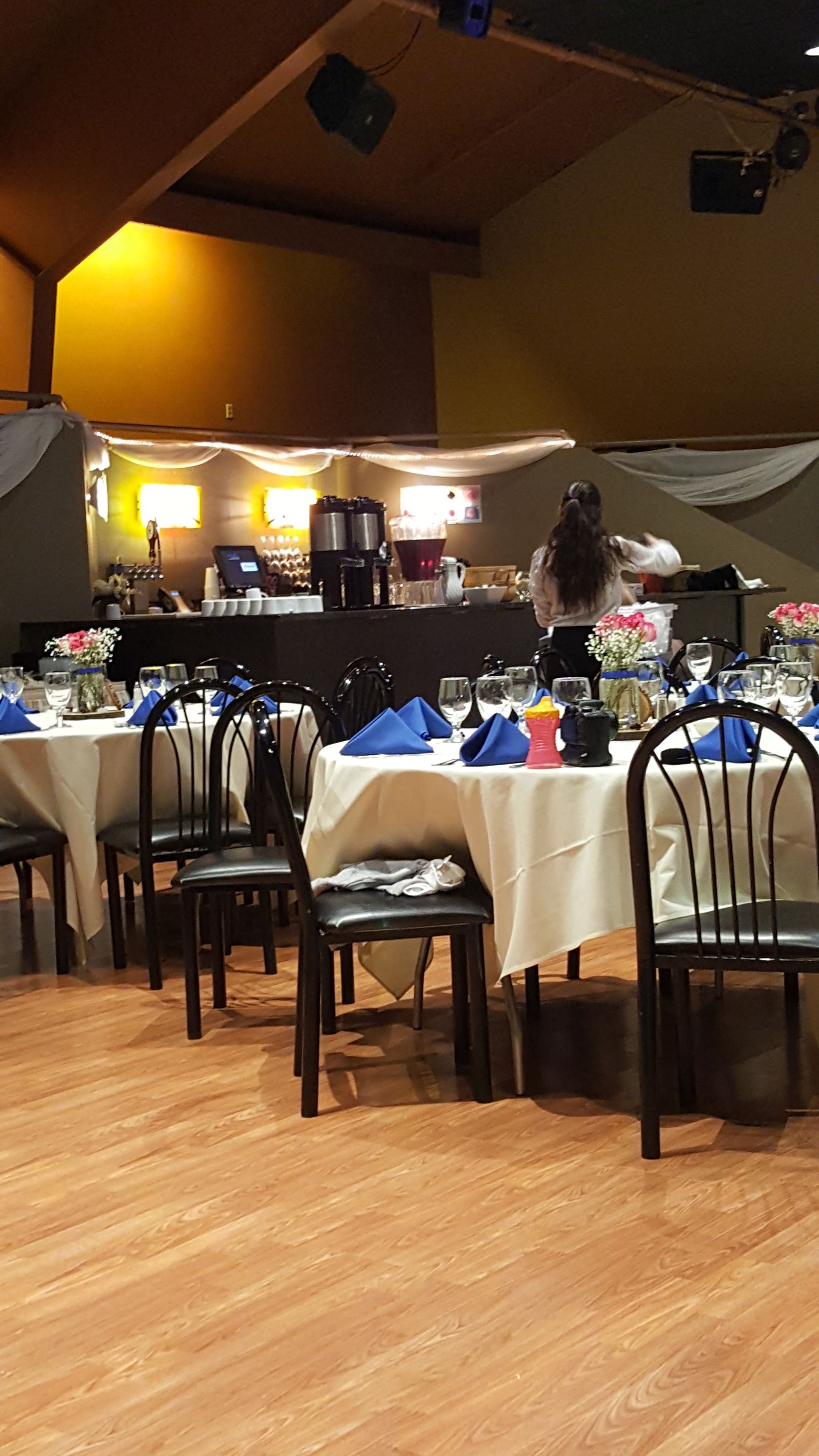Elegant banquet hall with round tables set for a formal event under warm lighting