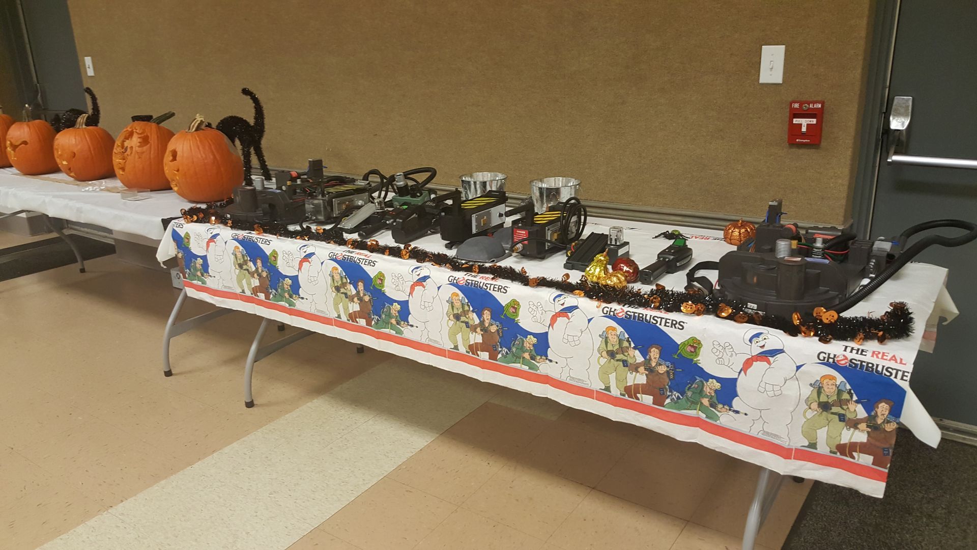 Halloween display of carved pumpkins and black craft items on tables in a decorated room