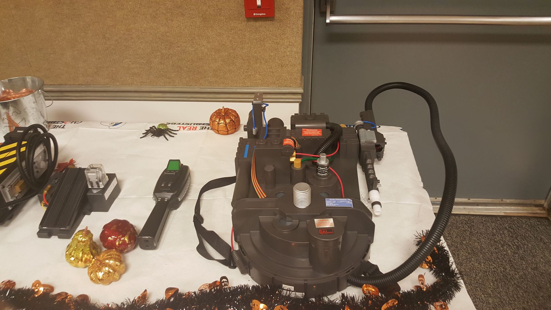 A vacuum cleaner beside festive decorations on a table in a room, with garland and ornaments nearby