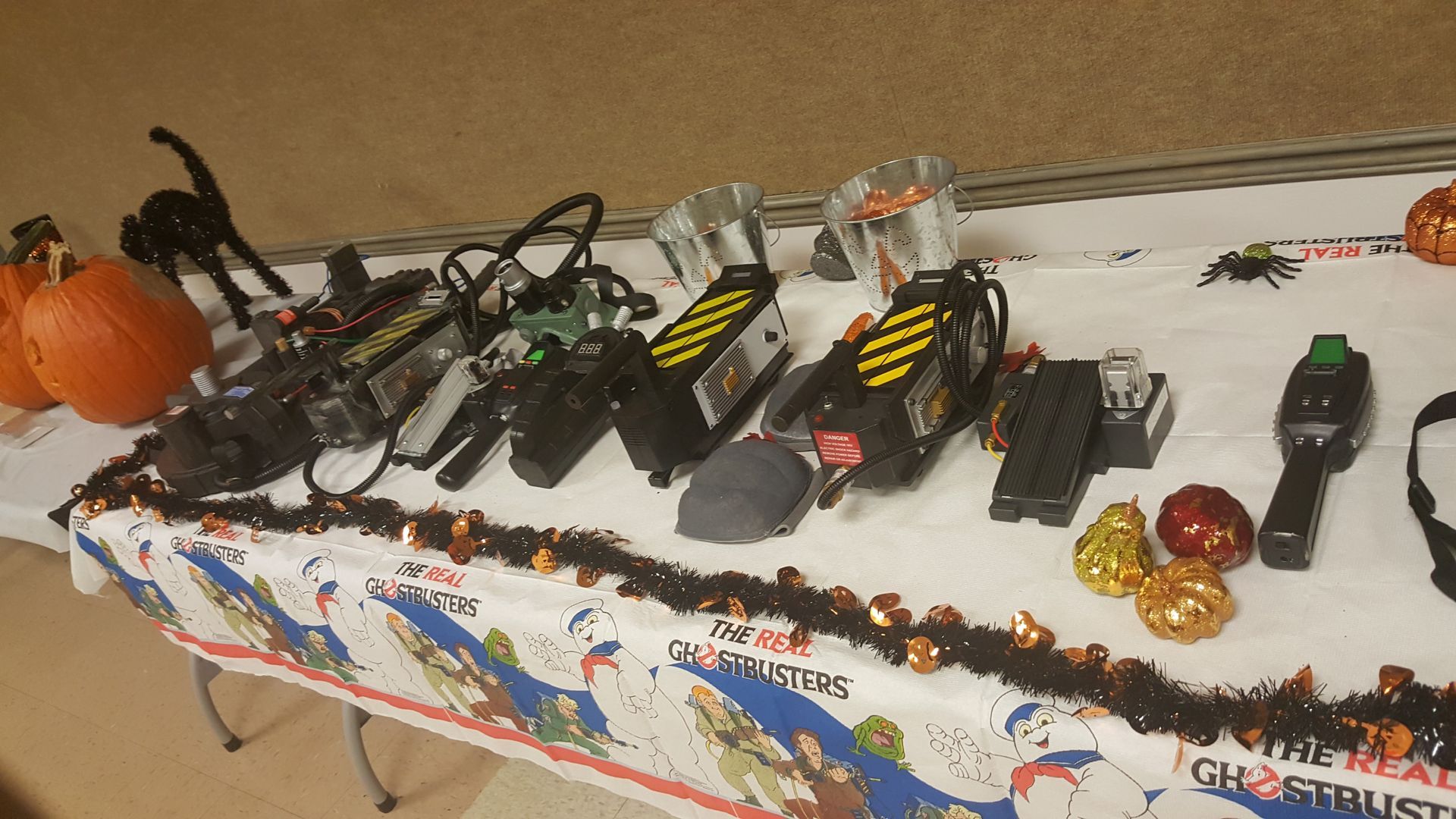 Halloween decorations and toys on a table, including pumpkins, bats, spiders, and small vehicles
